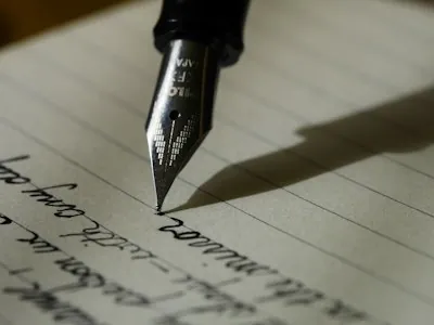 Hand schreibt in Notizbuch