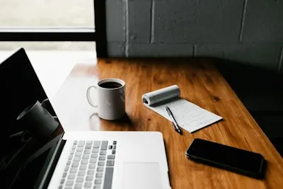 Laptop mit Kaffee auf Schreibtisch