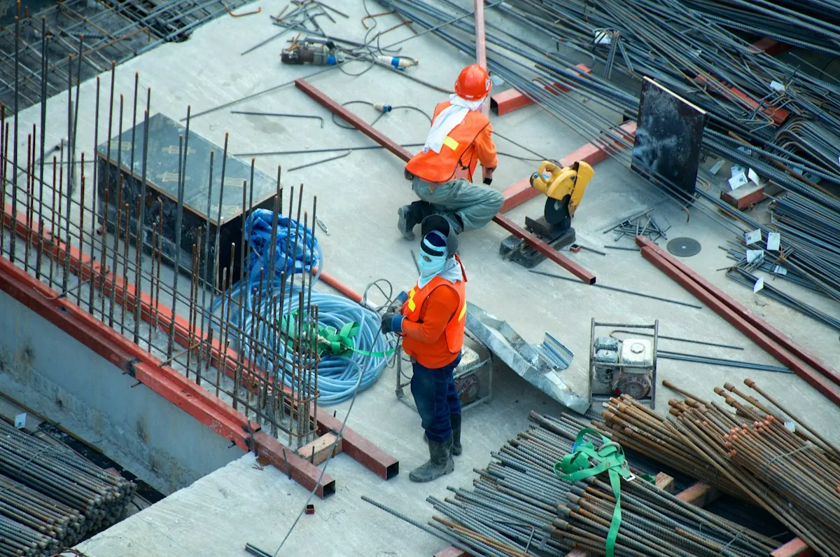 Handwerker auf einer Baustelle prüft Pläne — Auftragsplanung im Handwerk