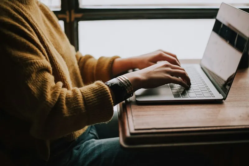 Person tippt auf Laptop — überzeugende Website-Texte schreiben