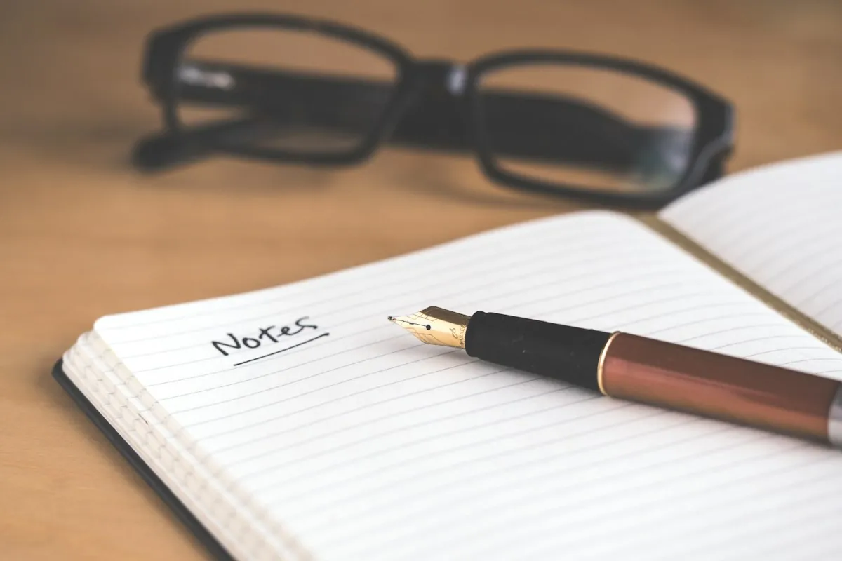 Notizbuch mit Stift auf Schreibtisch — Texte vorbereiten für die Website