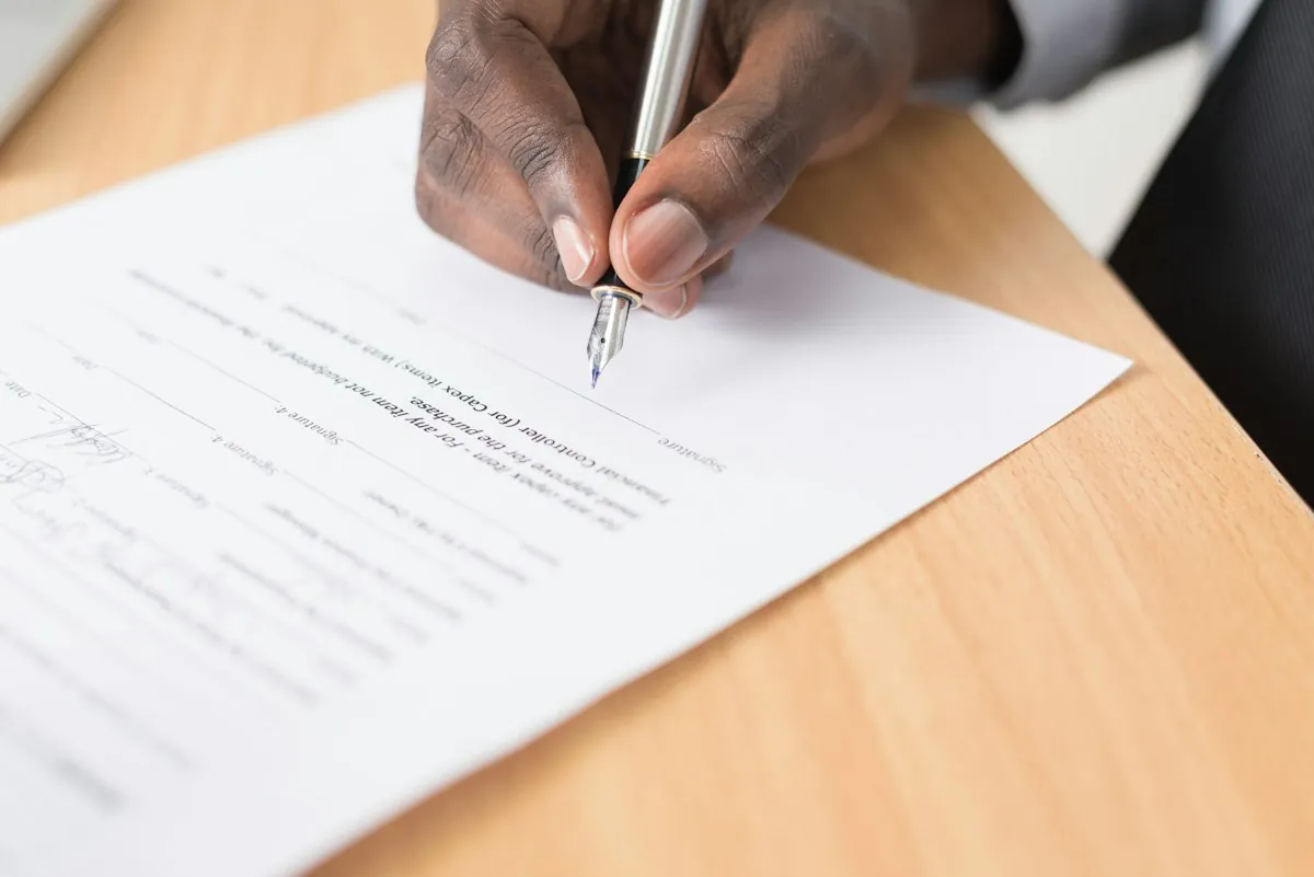 Unterschrift unter einem Vertragsdokument — Mandat beginnt online, endet im Beratungszimmer