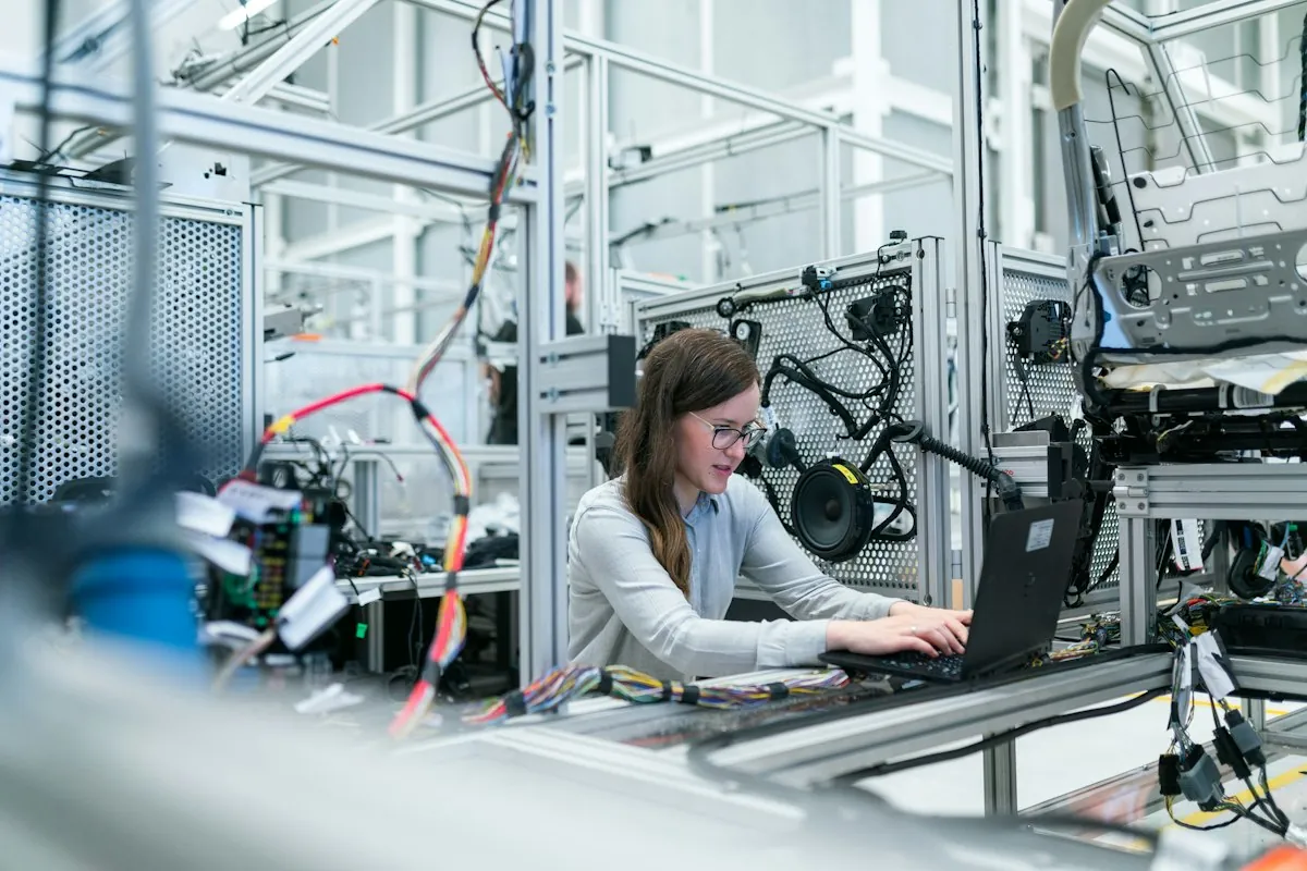 Person mit Laptop in moderner Werkstatt