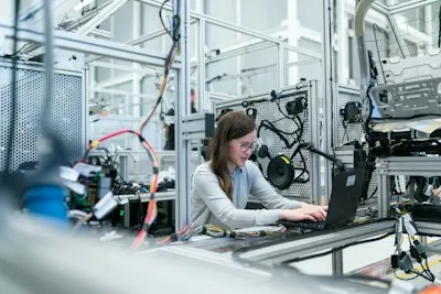 Person mit Laptop in moderner Werkstatt